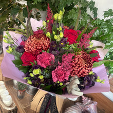 Load image into Gallery viewer, luxury blood red and black vampire Lestat inspired bouquet of flowers standing amongst green plants an tied with lace at florist shop in leighton buzzard Halloween bouquet
