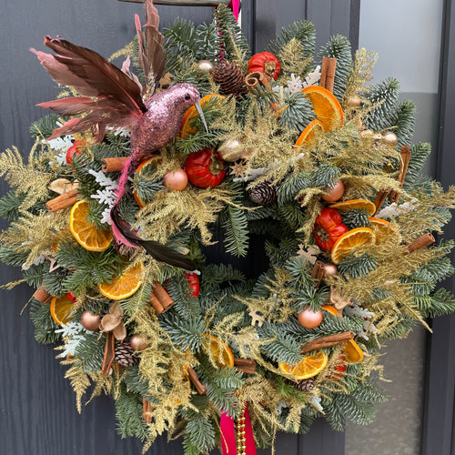 an over the top kitsch Christmas door wreath with a glittery bird and gold fern inspired by pantomimes from bits and buds florist leighton buzzard