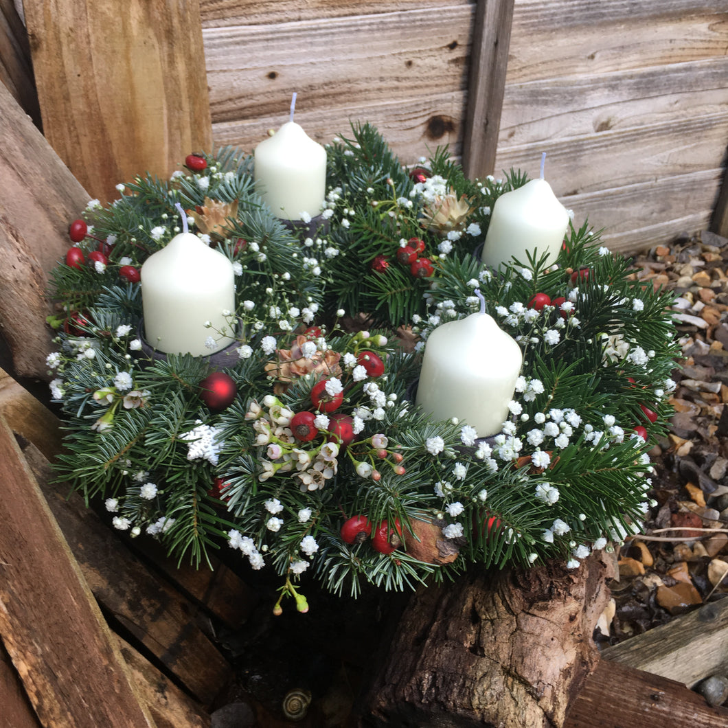 traditional advent wreath with 4 candles and traditional Christmas decorations. 
