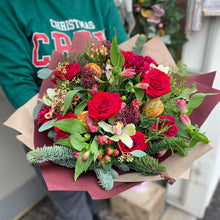 Load image into Gallery viewer, florist holding a luxury Christmas bouquet of red roses at bits and buds in leighton buzzard 
